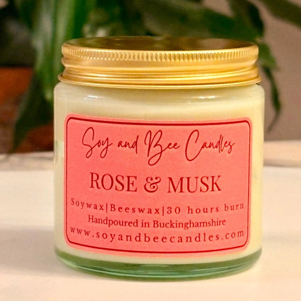 Soy and Bee Candles rose & musk candle with a gold lid on a neutral background