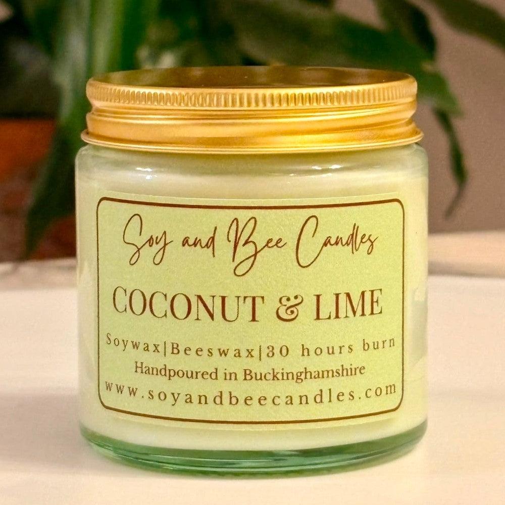 Soy and Bee Candles coconut & lime candle with a gold lid on a neutral background