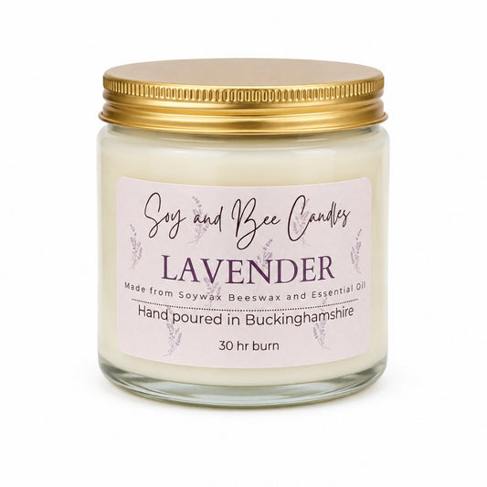 Lavender candle in a glass jar with a gold lid on a white background