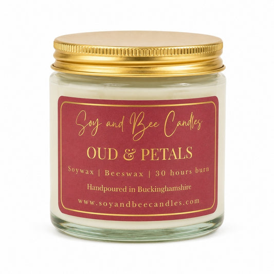 Candle jar with a gold lid and maroon label on a white background